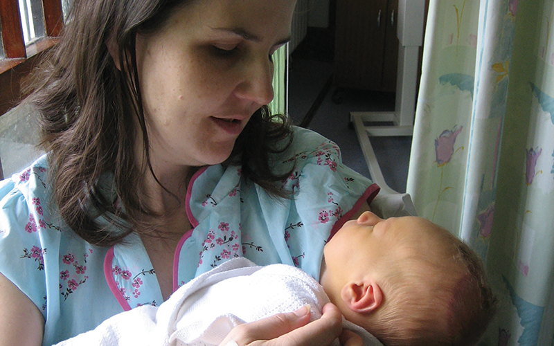 Mother holding her sleeping newborn baby.